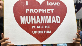 A man holding a sign reading: "I love Prophet Muhammad, peace be upon him."