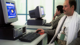 A Yemeni man in traditional gear browses the internet at a computer club in Sanaa 05 July 2002