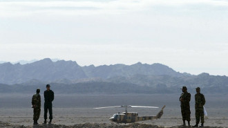 Iranian soldiers stand guard on a mound built to prevent drug trafficking 02 December 2003 in the Mirjaveh point where the borders of Iran, Afghanistan and Pakistan meet. (Photo by BEHROUZ MEHRI/AFP via Getty Images)