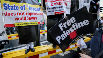 Anti Zionist placards are held with a Free Palestine sign near Trafalgar Square. 