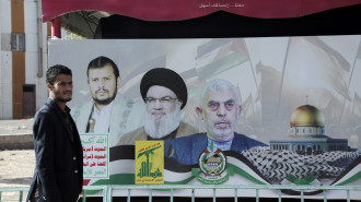 A Yemeni man walks next to a billboard with images depicting the Houthi leader Abdul-Malik Badreddin al-Houthi, Lebanon Hezbollah leader Hasan Nasrallah, and Yahya Sinwar, the Hamas military leader in the Gaza Strip, displayed in an exhibition launched in solidarity with Palestinians and against the Israeli sustained bombardment in Gaza on January 31, 2024, in Sana'a, Yemen. (Photo by Mohammed Hamoud/Getty Images)