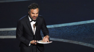 Mark Ruffalo in a suit, speaking into a microphone