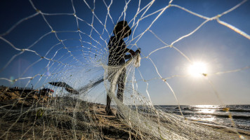 A Palestinian fisherman prepares his fishnets along a beach off the Mediterranean Sea in Rafah in the southern Gaza Strip on September 2, 2020. (Photo by SAID KHATIB / AFP) (Photo by SAID KHATIB/AFP via Getty Images)