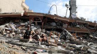 Destruction in Gaza caused by Israeli bombing. A boy sits amid the rubble.