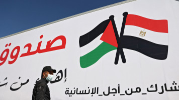 A member of the Palestinian security forces stands in front of an Egyptian aid truck arriving at the Rafah border crossing, which connects the Gaza Strip to Egypt, on May 23, 2021.[AFP via Getty]