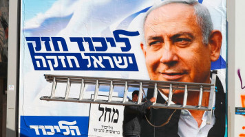 A man walks past an electoral campaign poster bearing the portrait of Benjamin Netanyahu, leader of the Likud party, in Tel Aviv on April 3, 2019, ahead of the general election scheduled for April 9. [Getty]