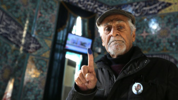 An Iranian man displays his ink-stained finger after casting his ballot during the parliamentary election on 21 February, 2020. [Getty]