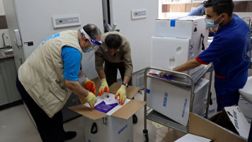 UN employees deliver the Pfizer/BioNTech Covid-19 vaccine at the ministry of health in Gaza City, on May 25, 2021. - A ceasefire was reached late last week after 11 days of deadly violence between Israel and the Hamas movement which runs Gaza, stopping Israel's devastating bombardment on the overcrowded Palestinian coastal enclave which, according to the Gaza health ministry, killed 248 Palestinians, including 66 children, and wounded more than 1,900 people. Meanwhile, rockets from Gaza claimed 12 lives in 