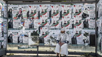 An elderly man sits in a bus station covered with electoral posters of a candidate of the "Future Front" political party in Algeria's capital Algiers on June 11, 2021, one day before Algeria's legislative elections. 