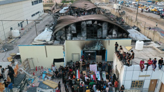 People place fake coffins in front of the fire-ravaged coronavirus isolation ward of Al-Hussein hospital, during a protest in the southern Iraqi city of Nasiriyah, on July 15, 2021. [Getty]