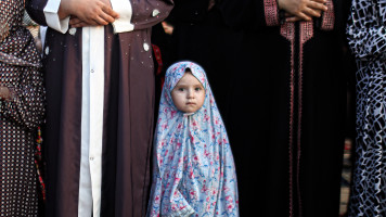 A Palestinian girl performs Eid al-Adha prayers in the southern Gaza Strip. [Getty]