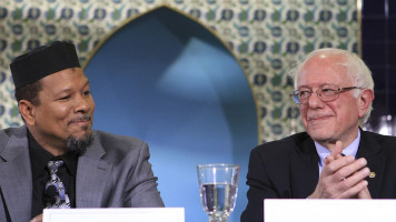 U.S. Senator of Democrats Bernie Sanders (R) gives a speech as Imam of the Masjid Muhammad Talib Shareef (L) is listening to him during an inter-religious gathering