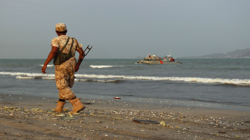 Pro-gvmnt Yemeni soldier walks along Aden coast