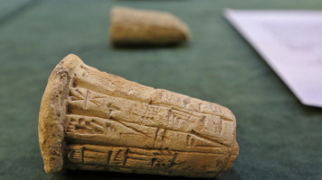 Mesopotamian clay cones bearing cuneiform inscriptions are displayed during a handover ceremony of a trove of looted Iraqi antiquities [Getty]