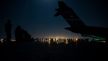 An air crew prepares to load evacuees aboard a C-17 Globemaster III aircraft in support of the Afghanistan evacuation at Hamid Karzai International Airport on August 21, 2021. [Getty]