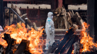 A man wearing PPE (Personal Protection Equipment) performs the last rites to his relative who died of Covid-19 at a crematorium on 20 April, 2021 in New Delhi, India. [Getty]