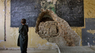 An Afghan child stands inside the ruins of the devastated but functioning Habibia High School in Kabul, Afghanistan. [Getty]