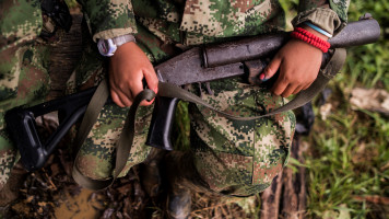 A member of the "Omar Gomez" Western War Front of the National Liberation Army (ELN) guerrilla holds her gun in a camp on the banks of the San Juan River, Choco department, Colombia, on November 20, 2017