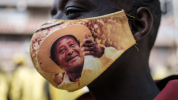 A supporter of the National Resistance Movement (NRM) wears a protective face mask printed with the portrait of President Yoweri Museveni [Getty Images]