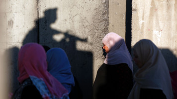 Palestinians wait to cross the Qalandia checkpoint between the West Bank city of Ramallah and Jerusalem during Ramadan in 2017. [Getty]