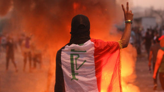 An Iraqi protester gestures the v-sign during a demonstration against state corruption, failing public services and unemployment at Tayaran square in Baghdad on October 2, 2019. [Getty]