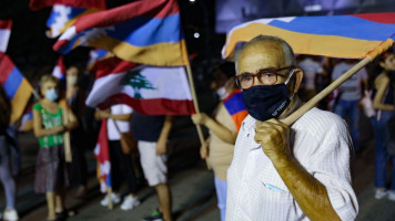 Lebanese of Armenian origin raise Armenian, national and Nagorno-Karabakh flags as they take part in a rally organised by the Tashnak party, in support of the Armenians of Nagorno-Karabakh, in the capital Beirut's eastern suburban neighbourhood of Bourj Hamoud [Getty Images]