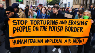 People hold a banner during 'Stop Tortures at the Border' protest in solidarity with refugees stuck at Polish-Belarusian border. Krakow, Poland on October 17, 2021 [Getty Images]