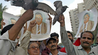 Pakistani men release pigeons for nuclear scientist Abdul Qadeer Khan (in portrait) during a rally in Karachi [Getty Images]