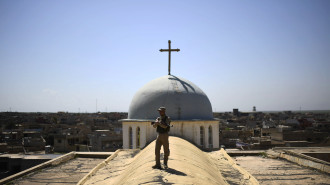 A Syriac Christian militiaman stands guard on top of the Saint John's church (Mar Yohanna) during an easter procession in the nearly deserted predominantly Christian Iraqi town of Qaraqosh (also known as Hamdaniya), some 30 kilometres from Mosul, on April 16, 2017.