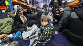 Migrants stay in the transport and logistics centre near the Bruzgi border point on the Belarusian-Polish border in the Grodno region on November 19, 2021