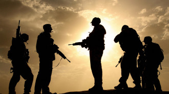 British soldiers from 21 Air Assault Battery Royal Artillery, who are providing the Helmand Task Force Provincial Reconstruction Team, are silhouetted against the sky as they provide security for a meeting with the Afghan National Police at the fortress Qala-e-Bost in Lashkar Gah, Helmand province.