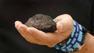 A man holding an extracted piece of ore