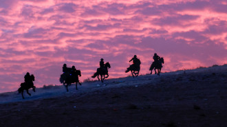 Mounted Israeli security forces ride on a hill during a protest by Beduins in the southern Israeli village of Sawe al-Atrash in the Neguev Desert, against an afforestation project by the Jewish National Fund (JNF), on January 13, 2022. - Bedouin, who are part of Israel's 20 percent Arab minority, have long opposed tree-planting initiatives in the Negev, blasting them as a de facto government land grab in areas they call home. (Photo by Menahem KAHANA / AFP) (Photo by MENAHEM KAHANA/AFP via Getty Images)