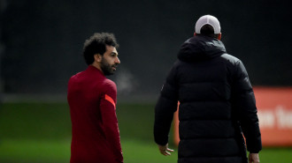 Liverpool's Mo Salah and Jurgen Klopp speaking on a pitch