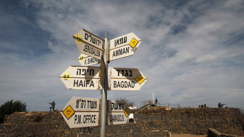 A sign for tourists shows the direction to Damascus and Baghdad among other destinations at an army post on Mount Bental in the Israeli-annexed Golan Heights on February 10, 2018. -