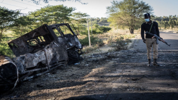 A police officer looks at a destroyed military truck in Kemise, Ethiopia