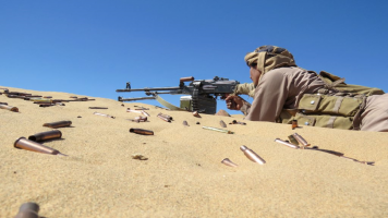 A Yemeni pro-government fighter takes aim from his position during fighting with Houthi rebels