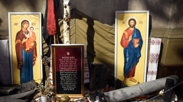 A picture shows military ammunition and Christian icons layed at a monument to fallen soldiers outside the Saints Peter and Paul Garrison Church in the western Ukrainian city of Lviv on March 7, 2022, 12 days after Russia launched a military invasion on Ukraine. 