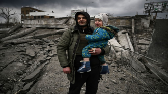 Man carrying child in Irpin, Ukraine