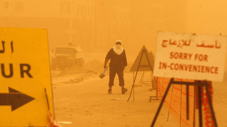 A Kuwaiti man walks in a street as a heavy sandstorm engulfs Kuwait city