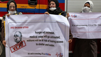 Humanitarian aid workers demonstrate against the closure of the Bab al-Hawa