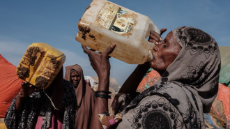 Hawa Mohamed Isack (R), 60, drinks water at a water distribution point at Muuri camp, one of the 500 camps for internally displaced persons (IDPs) in town, in Baidoa, Somalia