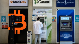 A woman uses a bank ATM next to a Bitcoin ATM machine at a shopping mall on April 16, 2021 in Istanbul, Turkey.