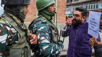 Indian paramilitary forces and Kashmiri men scuffle during a demonstration