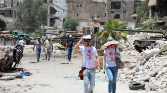 Actors are pictured in the Hajar al-Aswad neighbourhood of the Syrian capital Damascus on July 14, 2022, during the filming of a scene in a film titled "Home Operation", a Chinese-Emirati joint venture produced by actor Jackie Chan