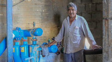 Farmer showing water use infrastructure for vineyard