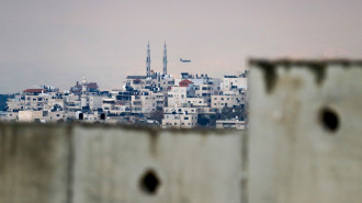 A picture shows the occupied West Bank village of al-Eizariya behind Israel's Apartheid wall on the outskirts of East Jerusalem [Getty Images]