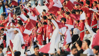 Fans cheer during a training session for the Qatar National Team at the Jassim bin Hamad stadium in the capital Doha