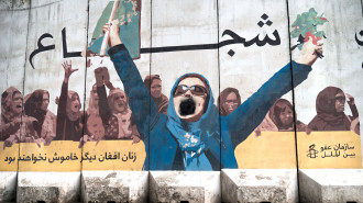 A wall mural of women with a writing "Afghan women will not be silent anymore" is depicted along a street in Kabul on January 10, 2023