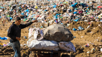 A Palestinian youth seen preparing himself to ride his cart at a large landfill in the town of Beit Lahia in the northern Gaza Strip